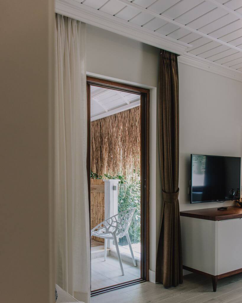 Luxurious hotel room interior with curtains and balcony access.
